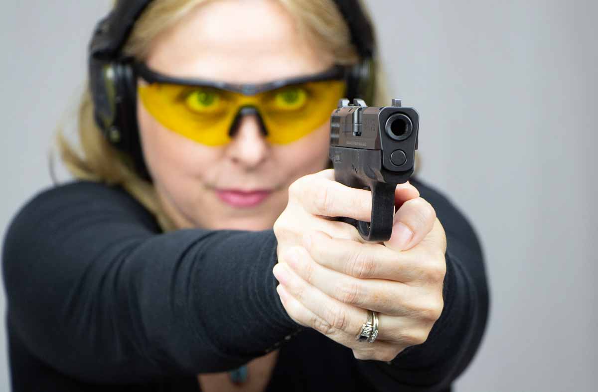 blonde woman shooting the Smith & Wesson Shield