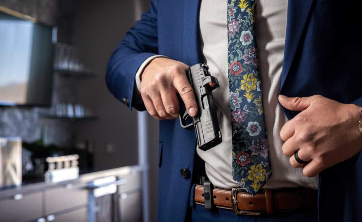 In this photo, we see a man drawing a Hellcat Pro from his Concealed Carry holster that is hidden under his sports coat jacket.